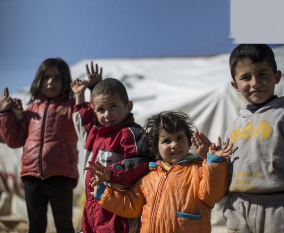 Children pose for a photograph at an informal settlement for Syrian refugees in Lebanon's Bekaa Valley.